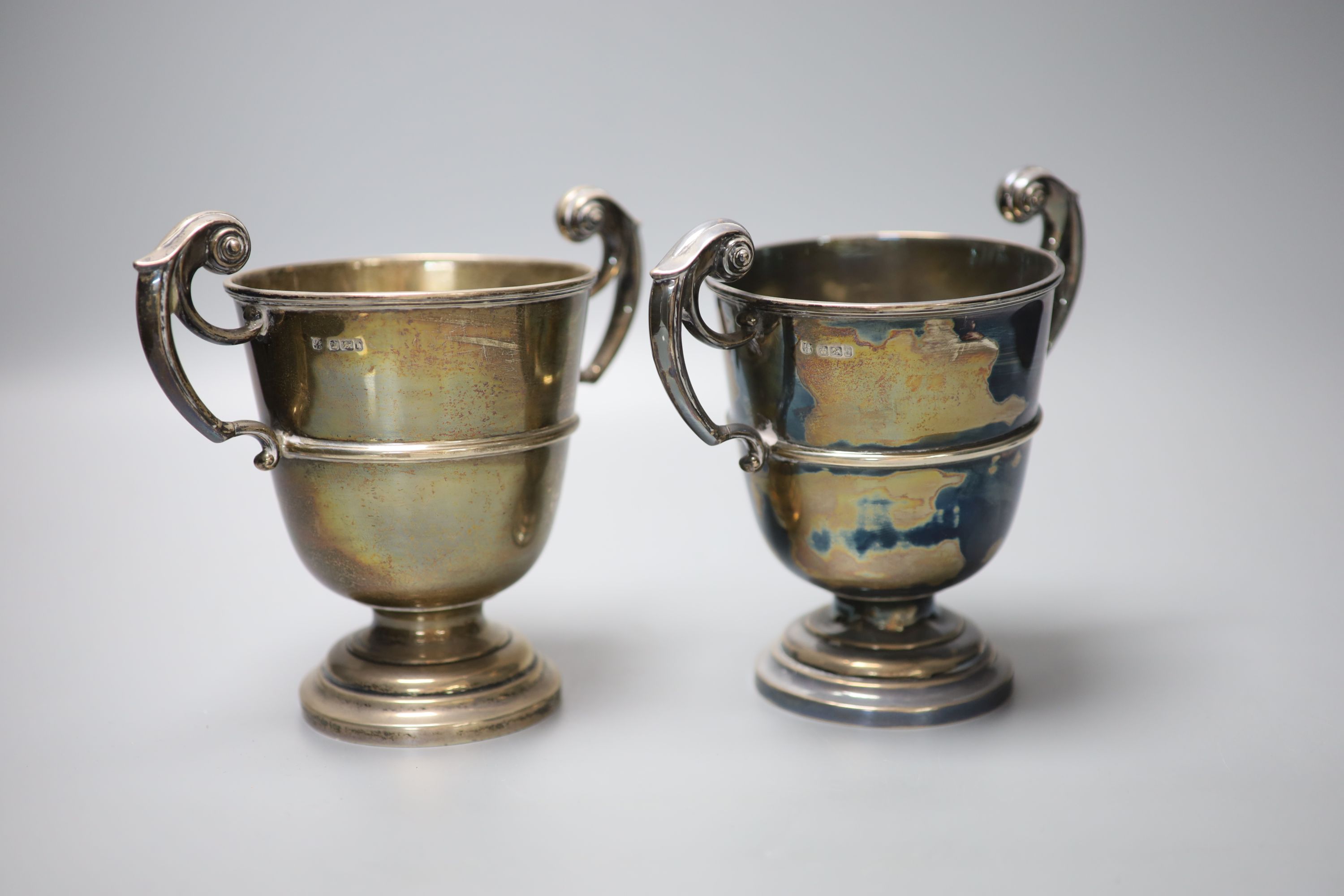 A pair of late Victorian silver two handled pedestal trophy cups, James Deakin & Sons, Sheffield 1900, 16cm, 28oz.